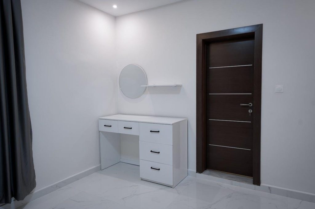 Une pièce blanche avec un bureau et un miroir.