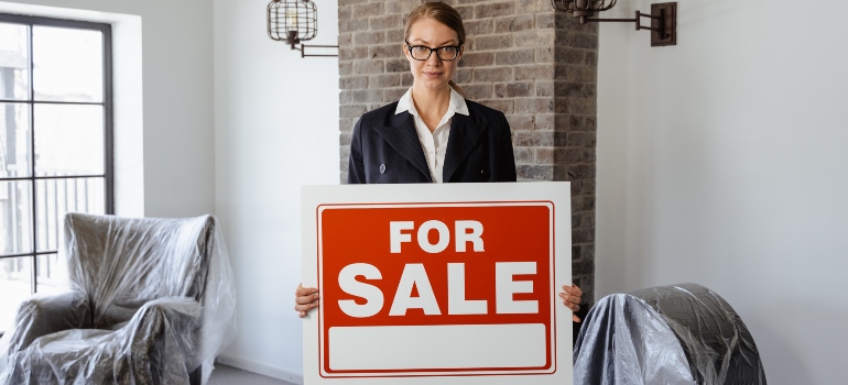 un agent immobilier avec une pancarte « À vendre »