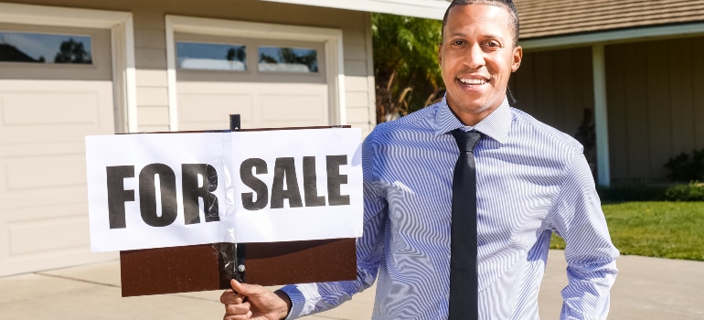a man with a for sale sign